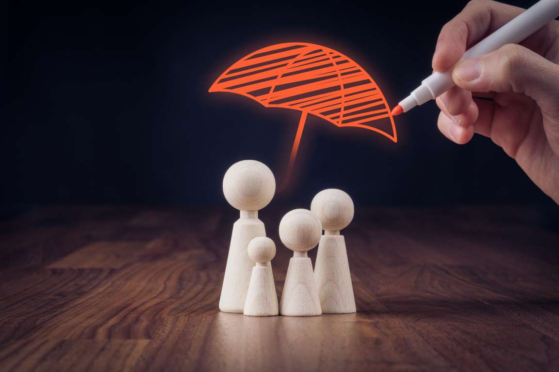 family-wooden-figures-under-drawn-red-umbrella