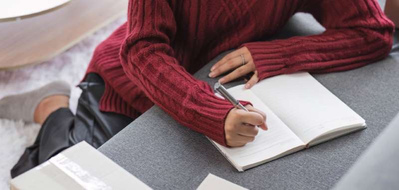 person-writing-wearing-red-jumper-800w